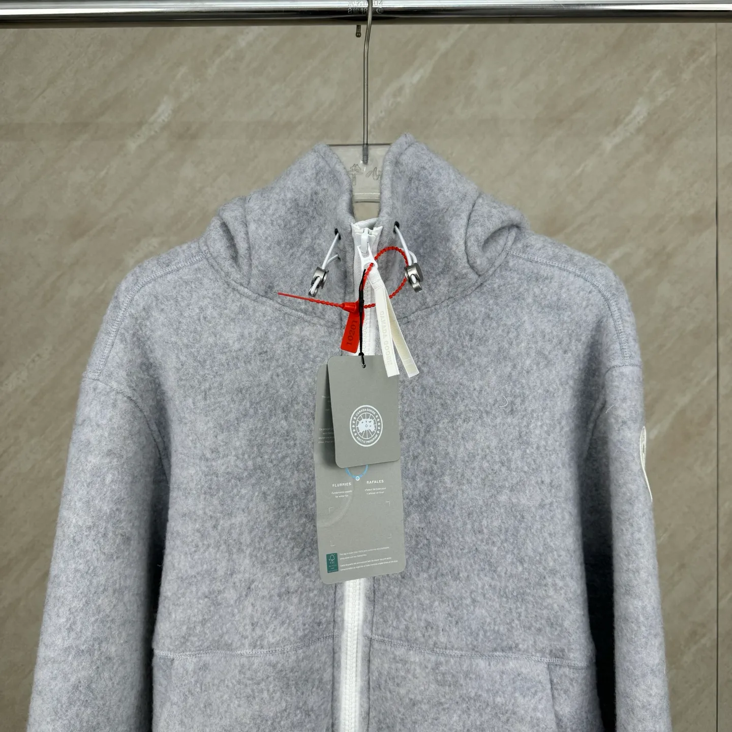 P810 Canada Goos Fleece Badge Hooded Jacket SIZE S/M/L/XL The fabric is made of wool as the main body, with a very small amount of spandex and polyester fiber blended into the wool fleece fabric. The sleeves and hem are closed with 2×2 ribbing. Its strong elasticity can closely fit wrists and waists of different thicknesses, forming an effective 'seal' to prevent cold wind from blowing back. It can still maintain its original shape after repeated stretching and use, and is not easy to loose and deform. And the ribbed cuffs can convey a sense of design and enhance the visual beauty.